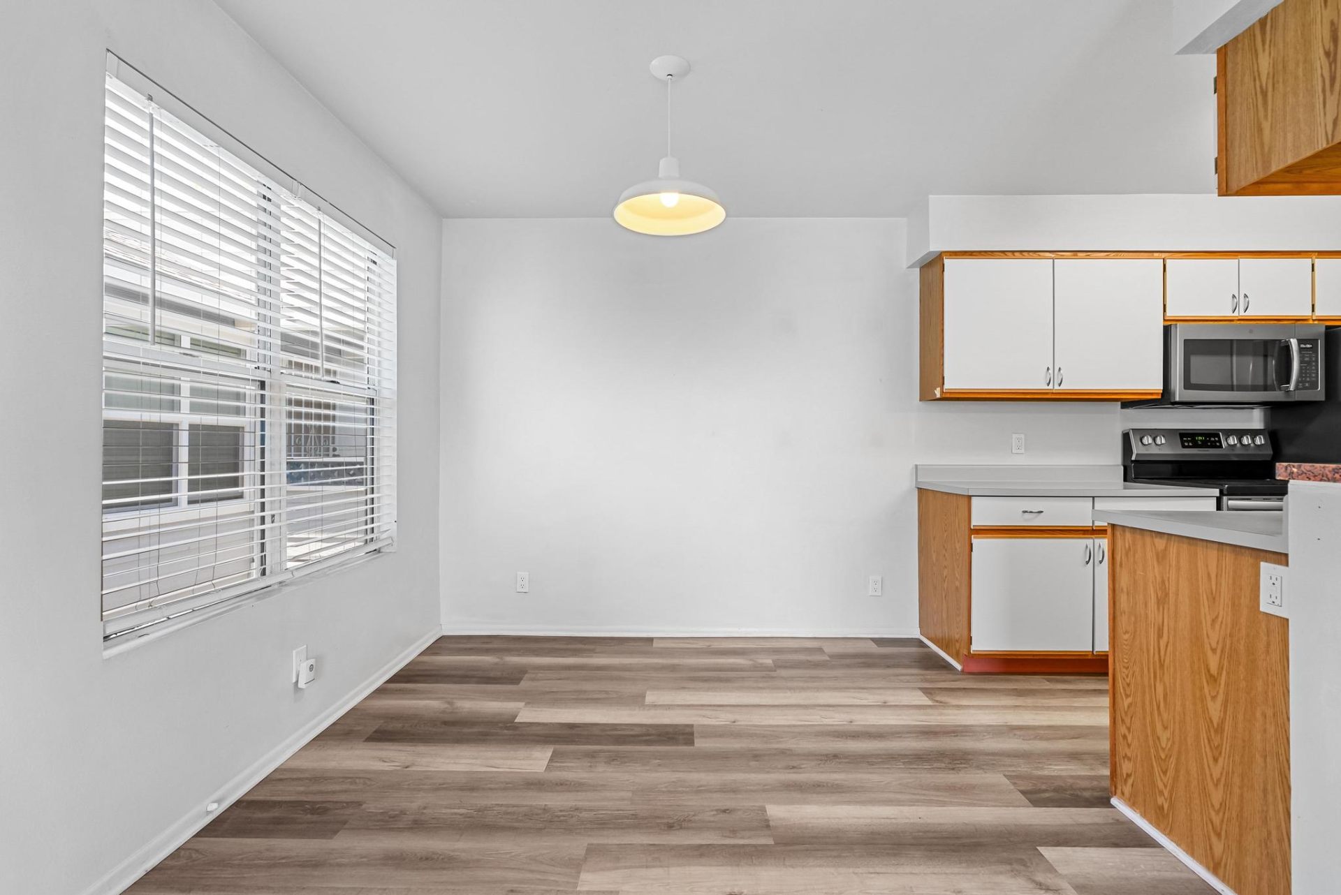 Dedicated dining area with large window and pendant light