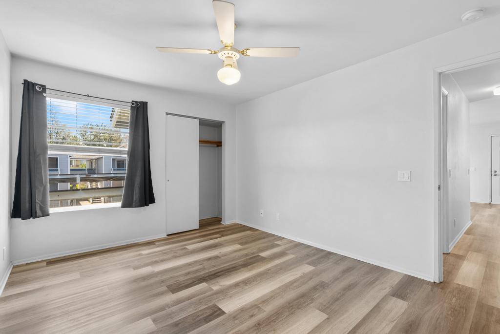 Primary bedroom with picture window and ceiling fan