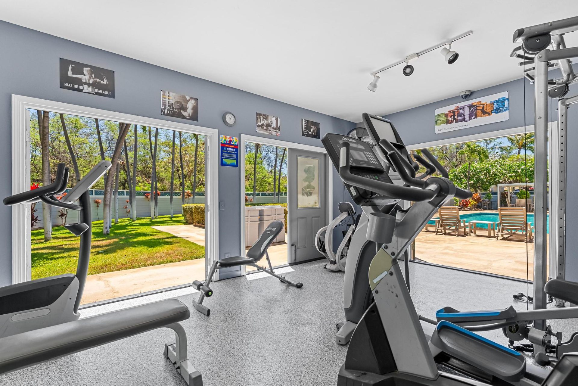 Fitness room with floor-to-ceiling windows overlooking the pool